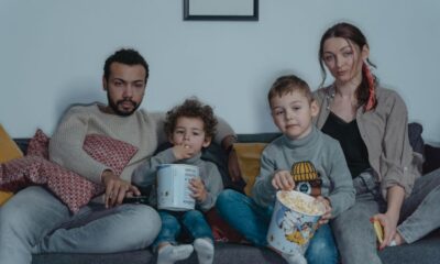 A family cuddled up together on the couch watching a kids' movie on Netflix
