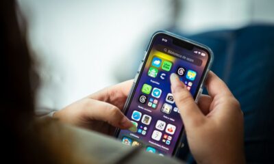 A person checking a cash back rewards app on their smartphone while shopping