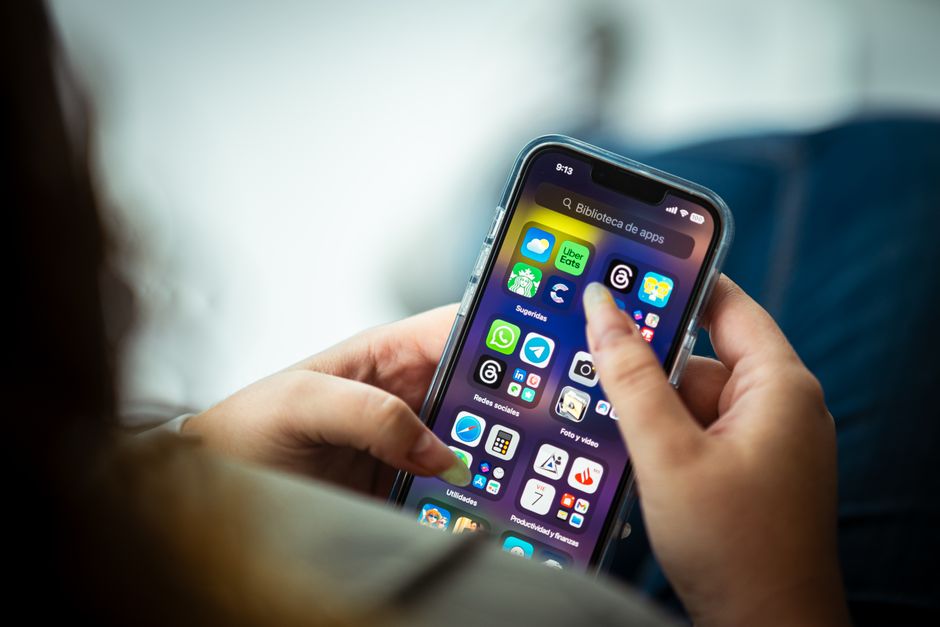 A person checking a cash back rewards app on their smartphone while shopping
