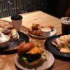 A spread of classic American comfort food dishes including mac and cheese, fried chicken, and apple pie on a wooden table