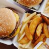 A tray of popular American fast food including a burger, fries, and a soft drink