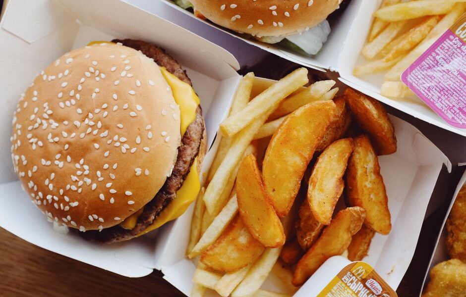 A tray of popular American fast food including a burger, fries, and a soft drink