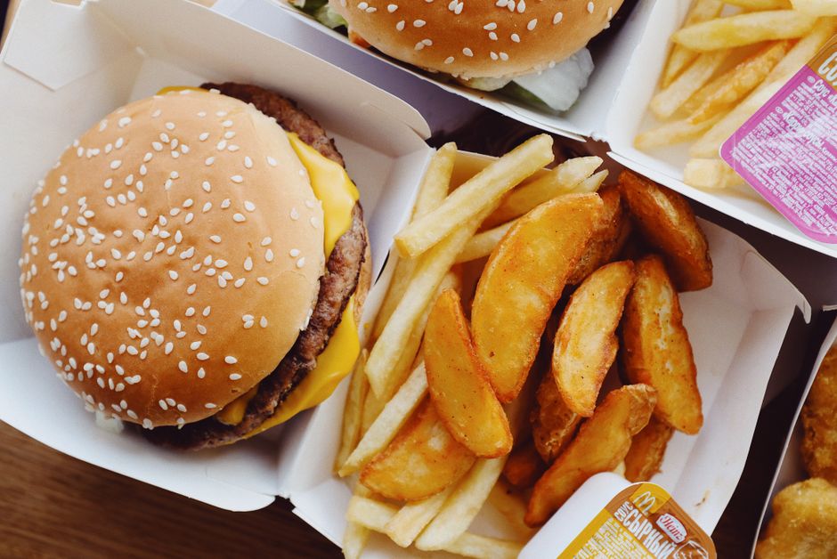 A tray of popular American fast food including a burger, fries, and a soft drink