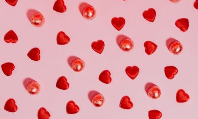 Collection of affordable Valentine's Day gifts under $50 including candles, jewelry, and a photo book arranged on a table