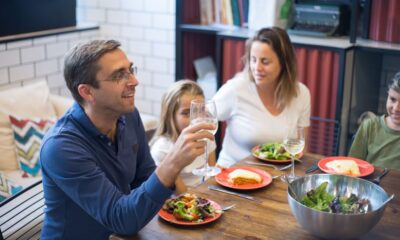 Family of four eating a cheap homemade dinner together at the kitchen table