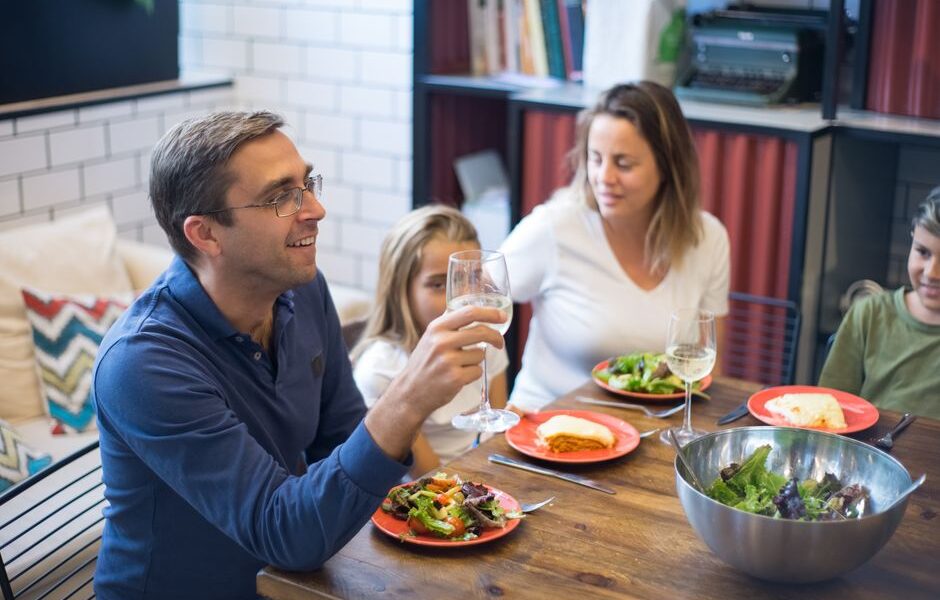 Family of four eating a cheap homemade dinner together at the kitchen table