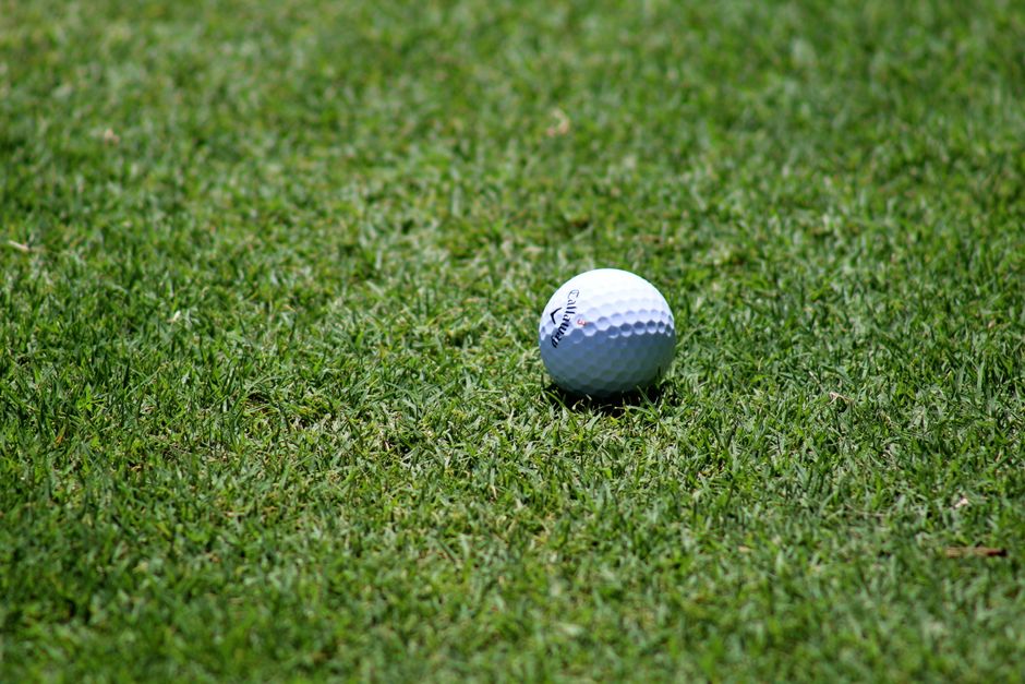 Golf course fairway in Arizona with desert mountains and cacti in the background