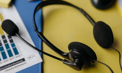 Person listening to top charting songs on headphones with a smartphone showing a music streaming app
