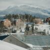 Snow-covered ski slopes and chairlifts at a Colorado ski resort with mountain peaks in the background