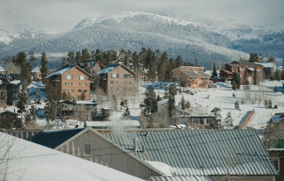 Snow-covered ski slopes and chairlifts at a Colorado ski resort with mountain peaks in the background