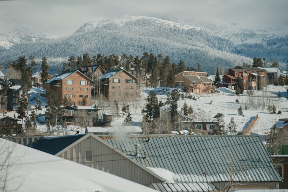 Snow-covered ski slopes and chairlifts at a Colorado ski resort with mountain peaks in the background