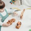 Toddler playing with colorful wooden educational toys on the floor