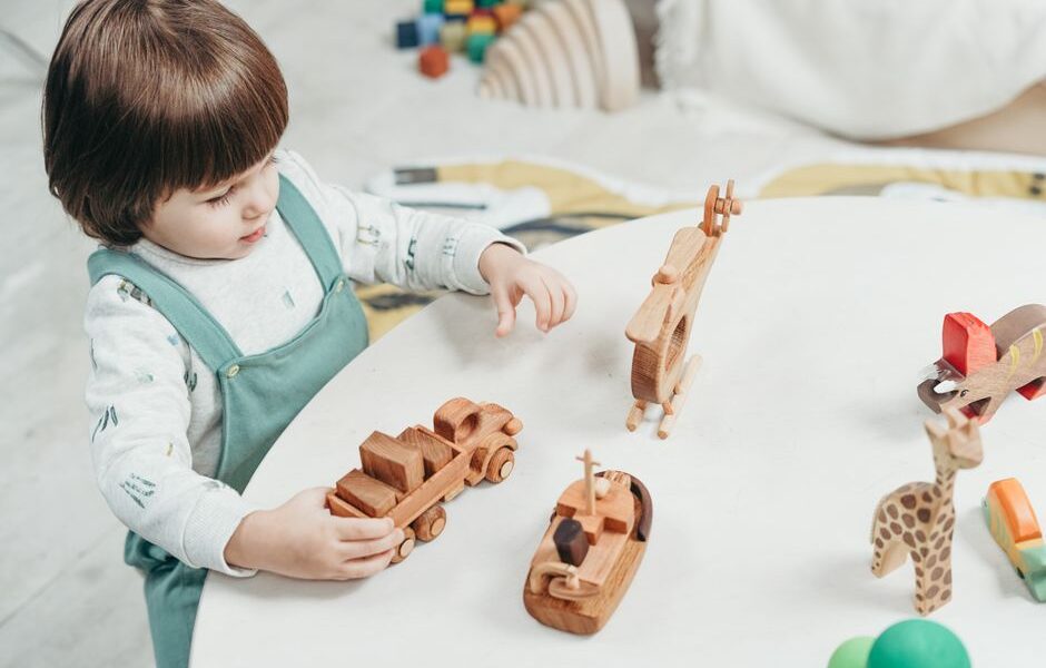 Toddler playing with colorful wooden educational toys on the floor