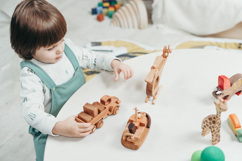 Toddler playing with colorful wooden educational toys on the floor