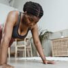 Woman performing push-ups on a yoga mat during a home workout