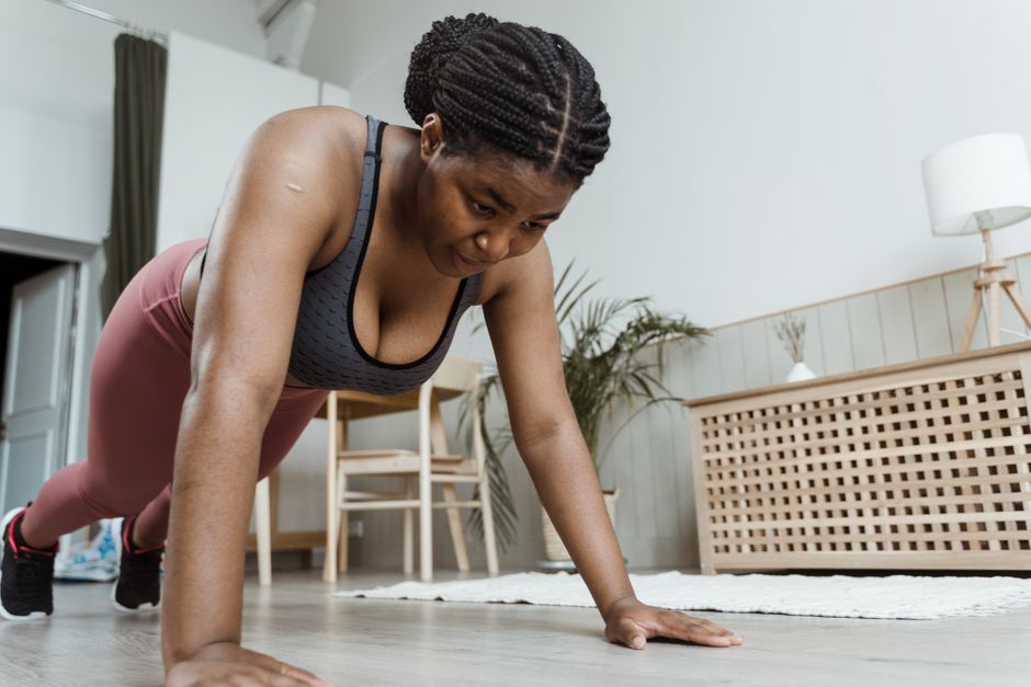 Woman performing push-ups on a yoga mat during a home workout