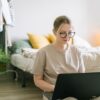 Woman working on a laptop at a home office desk while making money from home