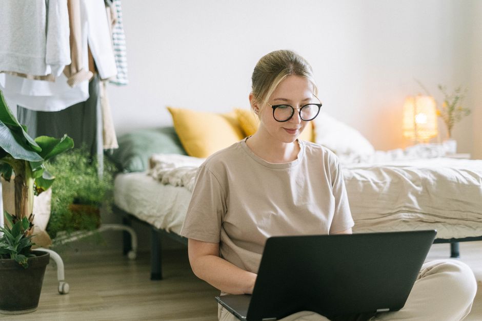 Woman working on a laptop at a home office desk while making money from home