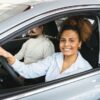 Driver reviewing auto insurance policy documents with a car in the background in New York