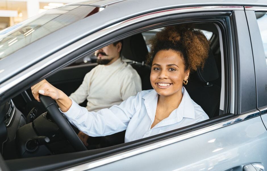 Driver reviewing auto insurance policy documents with a car in the background in New York