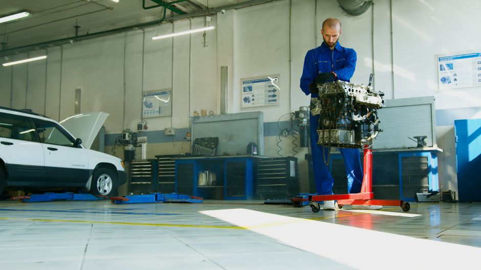 Mechanic repairing a car engine inside an auto repair shop in California