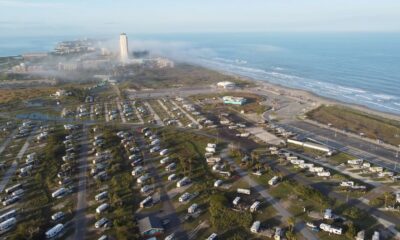 Rows of RVs and travel trailers parked at an RV dealership lot in Texas